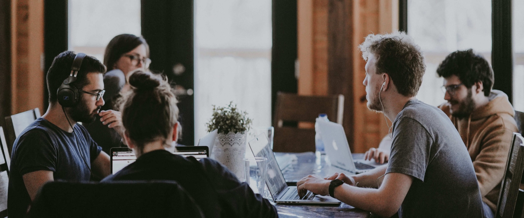 A team working together at a table with laptops.